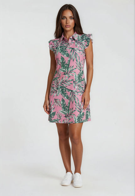 Woman wearing a Birdies and Bubbles pink dress with green leaf pattern on a white background