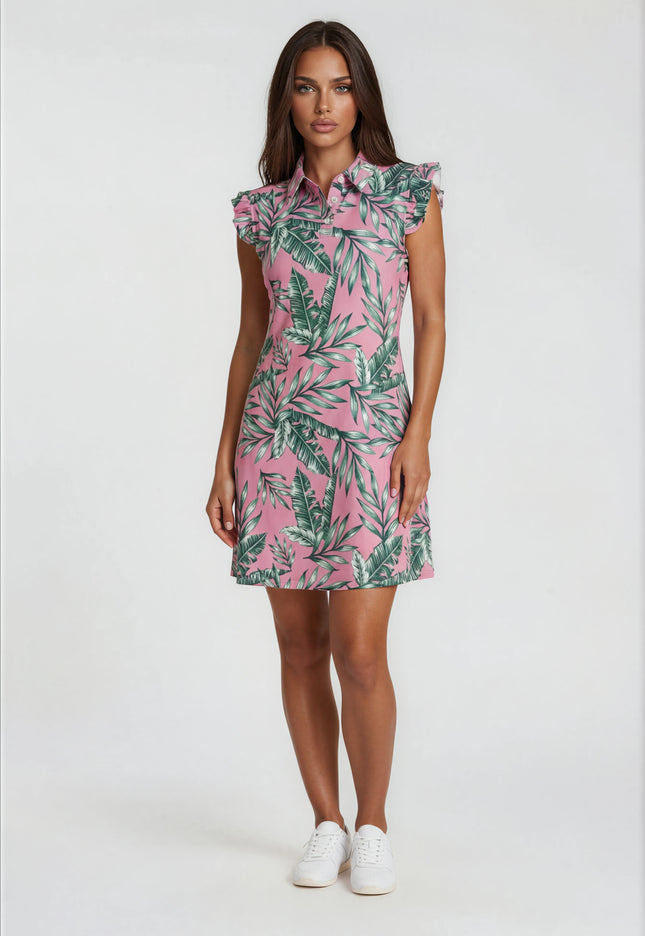 Woman wearing a Birdies and Bubbles pink dress with green leaf pattern on a white background