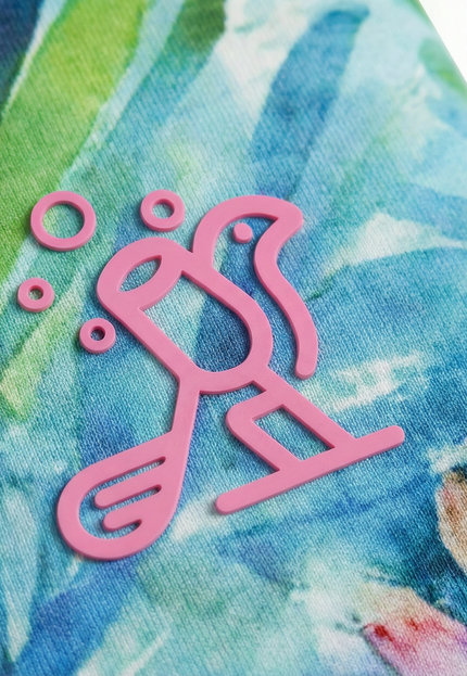 Close-up of a pink logo on a colorful fabric background